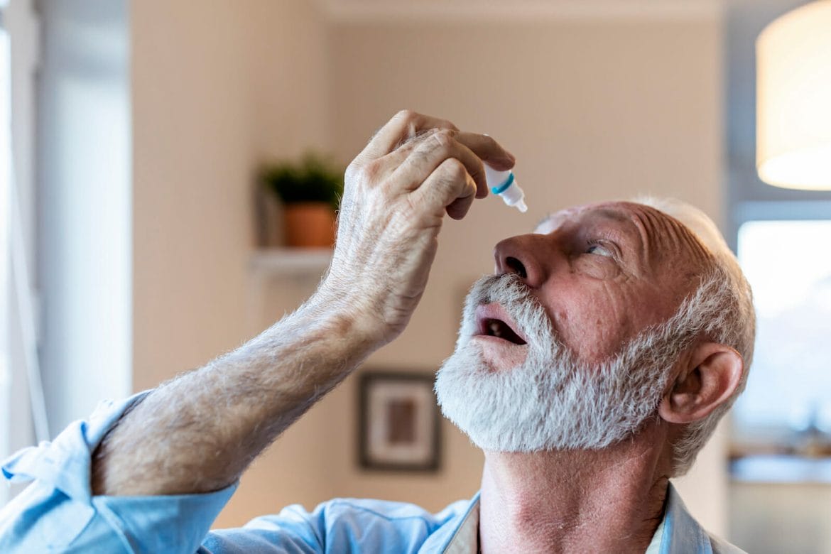 Man using eye drops for glaucoma