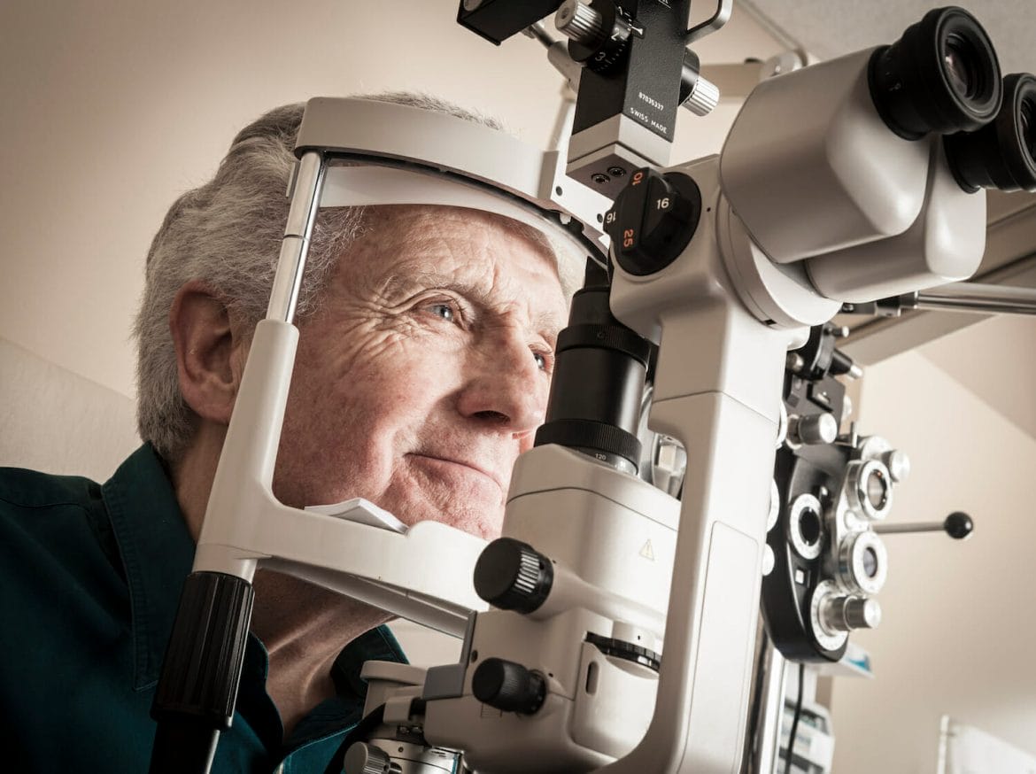 Ophthalmologist giving eye exam to senior patient