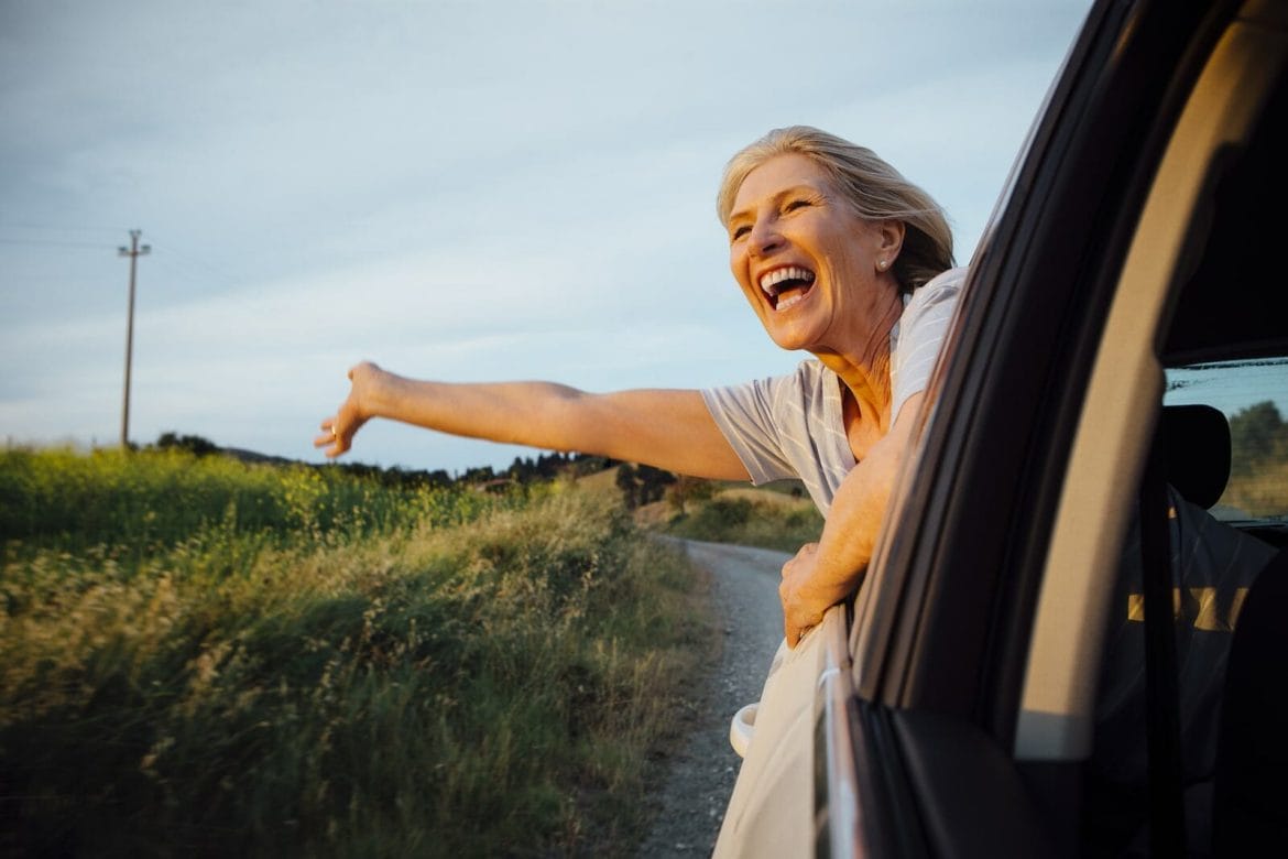 woman leaning out of car window, enjoying life, free of glaucoma eye drops after istent surgery