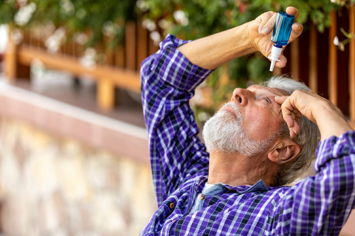 Senior Caucasian man inserting eye-drops